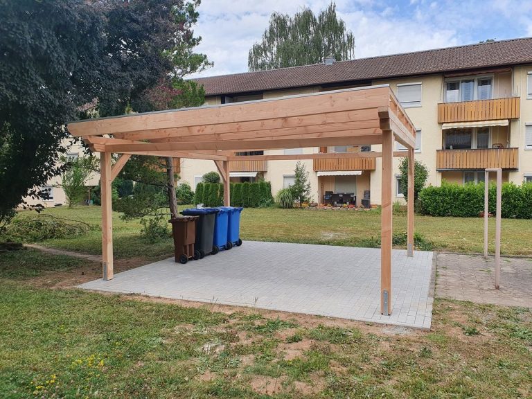 Holzcarport von der Seite mit Pfosten und Dachkonstruktion über einer Rasenfläche