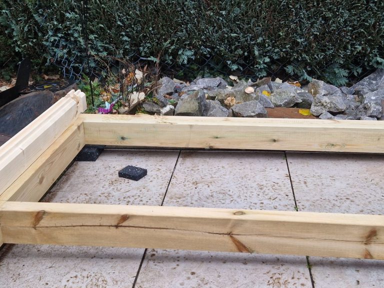 Fundamentrahmen aus Holz auf Betonplatten vor dem Aufbau eines Gartenhauses