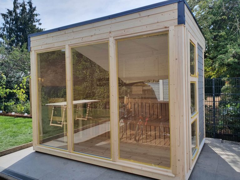 Saunahaus aus Holz mit großer Glasfront und Blick in den Innenraum