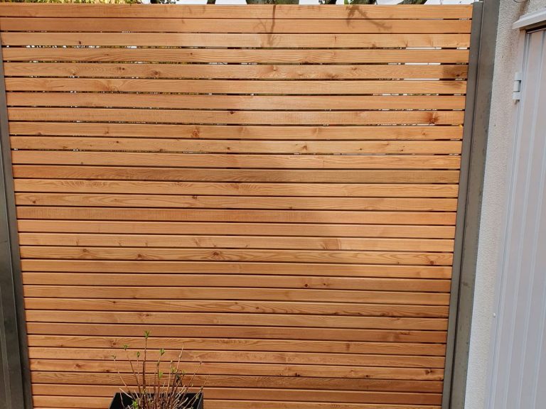 Sichtschutzzaun aus waagerechten Holzlamellen an einer Terrasse