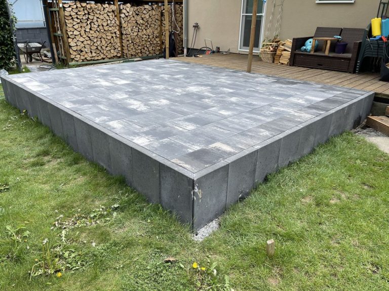 Ecke einer Plattenterrasse mit sichtbarem Randabschluss auf Rasenniveau